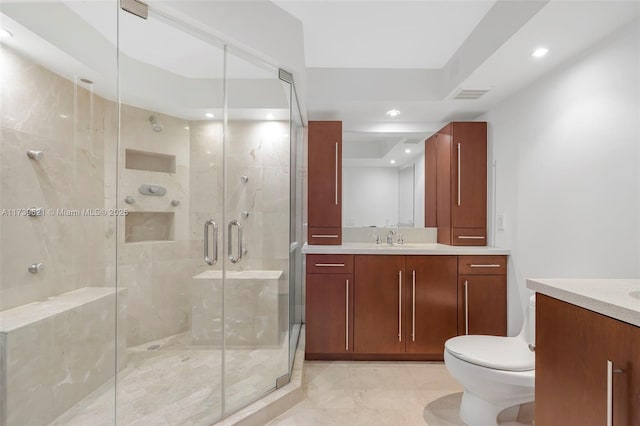 bathroom featuring a shower with door, vanity, and toilet