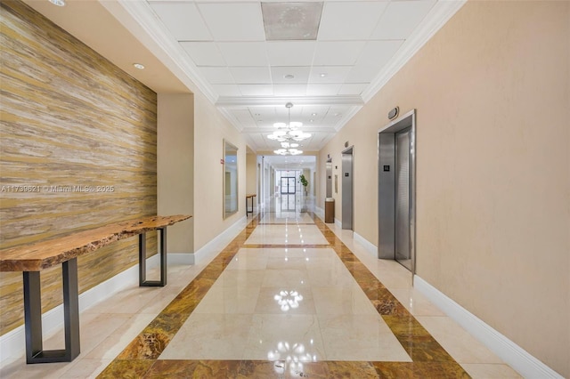 hallway with an inviting chandelier, ornamental molding, and elevator