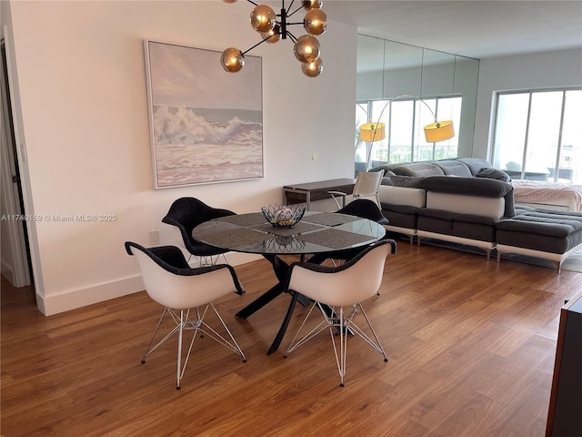 dining area featuring wood-type flooring and a chandelier