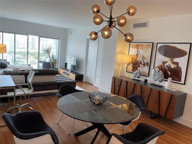 dining space with hardwood / wood-style floors and a chandelier