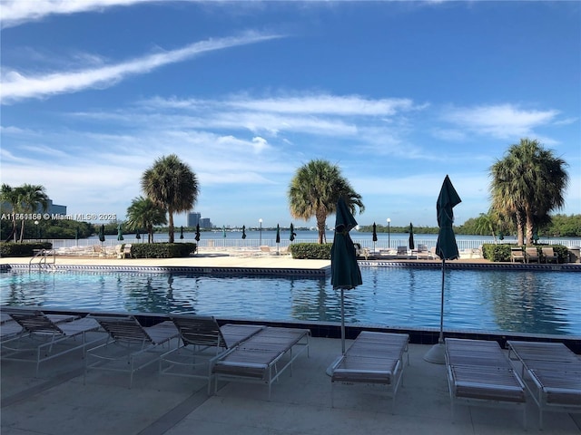 view of swimming pool with a patio area and a water view