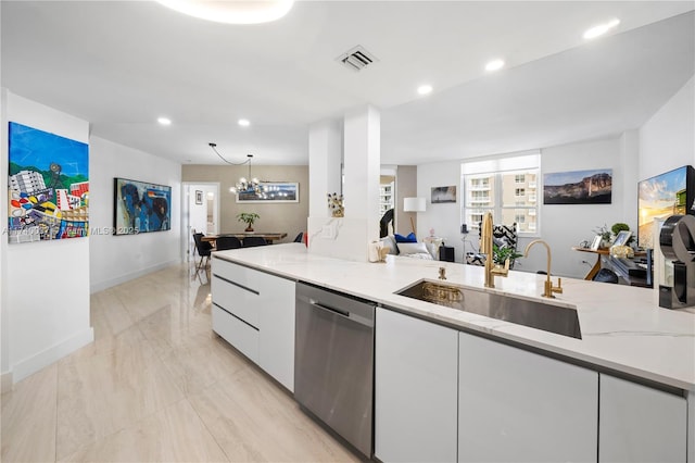 kitchen featuring white cabinetry, stainless steel dishwasher, light stone countertops, and sink