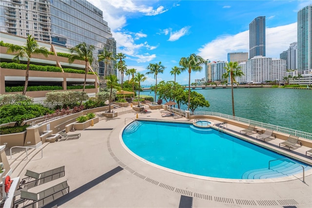 view of swimming pool with a water view and a patio area