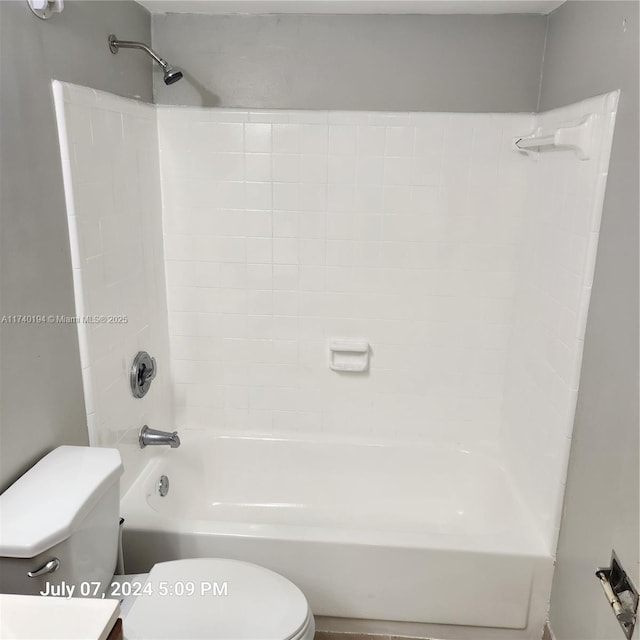 bathroom featuring tiled shower / bath and toilet