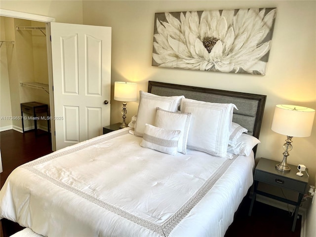 bedroom with dark hardwood / wood-style floors and a closet