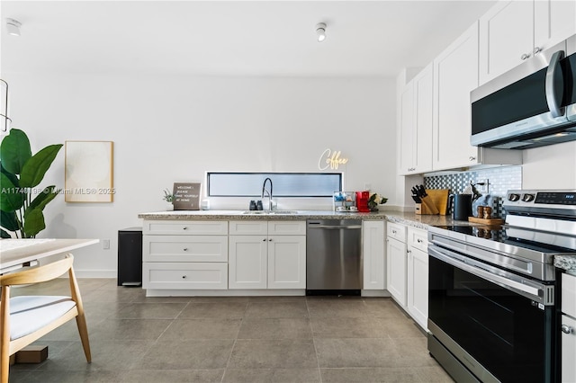 kitchen with white cabinetry, sink, decorative backsplash, and appliances with stainless steel finishes