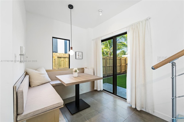 dining area with breakfast area and dark tile patterned flooring