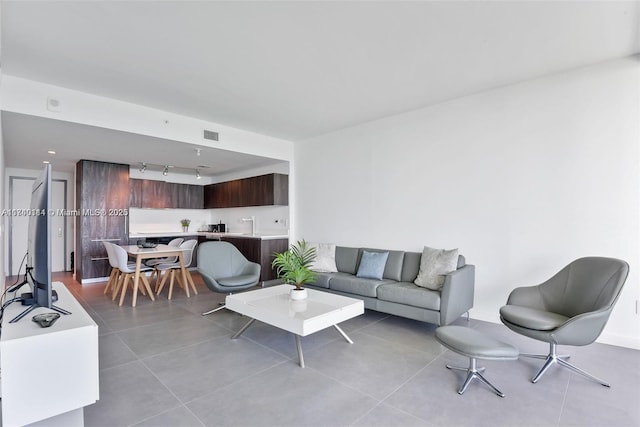 tiled living room featuring track lighting