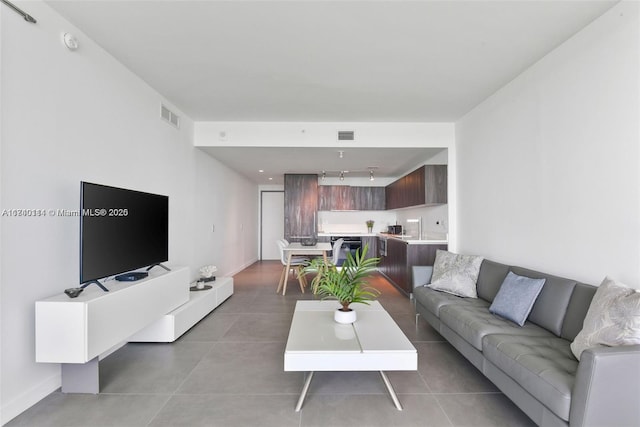 living room featuring rail lighting and tile patterned floors