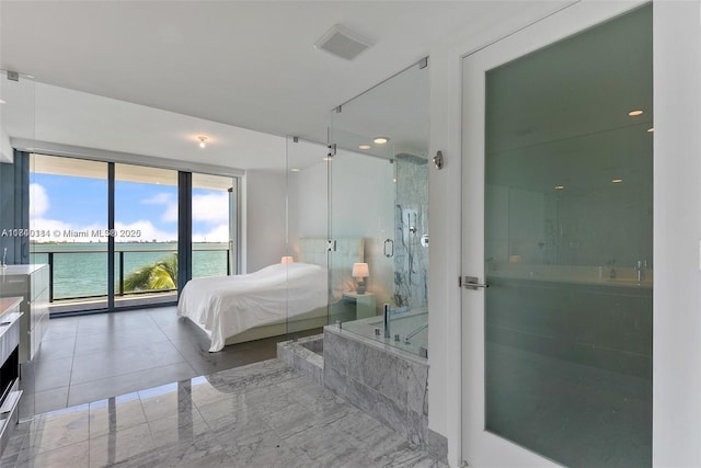 bedroom featuring a water view and access to exterior