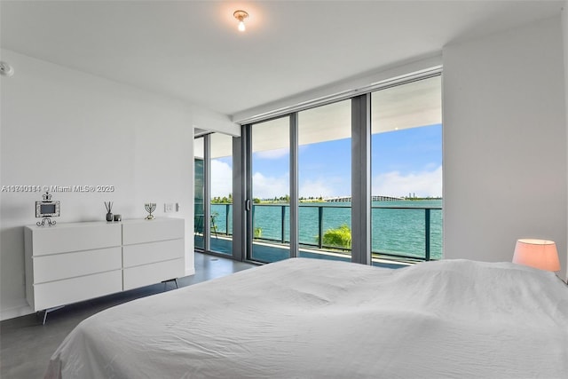 bedroom with a water view, a wall of windows, and access to outside