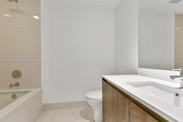 full bathroom featuring tile patterned flooring, vanity, tiled shower / bath, and toilet