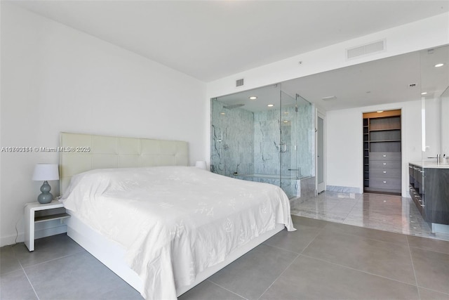 tiled bedroom featuring a spacious closet