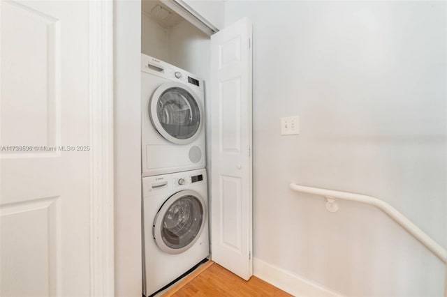 laundry area with stacked washer / dryer and hardwood / wood-style floors