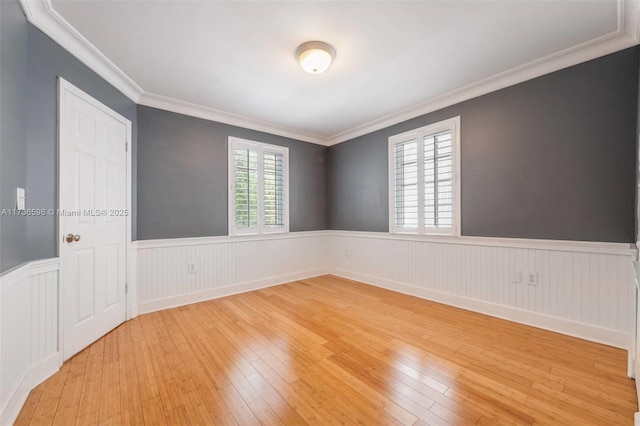 empty room with light hardwood / wood-style flooring and ornamental molding