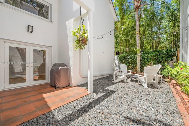 view of patio with grilling area, french doors, and an outdoor fire pit