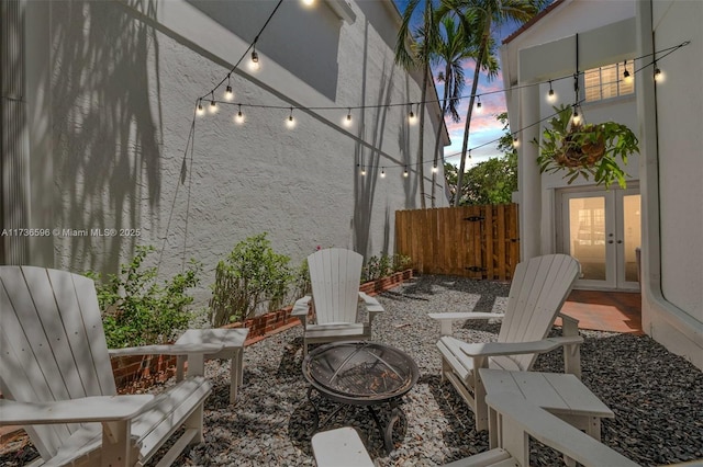 patio terrace at dusk featuring french doors and an outdoor fire pit