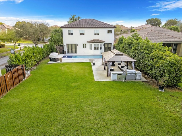 back of property with a patio, a tiled roof, a gazebo, fence, and a yard