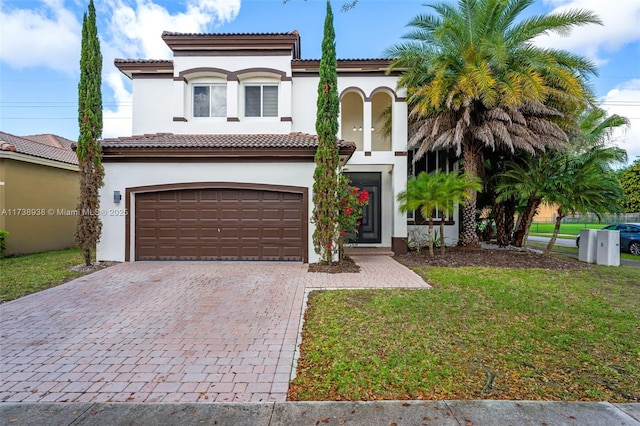 mediterranean / spanish-style home featuring decorative driveway, a tile roof, a front lawn, and stucco siding