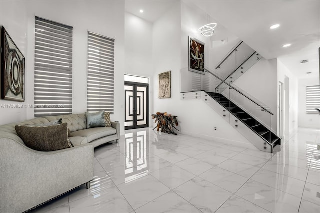 living room featuring a towering ceiling, marble finish floor, french doors, and recessed lighting