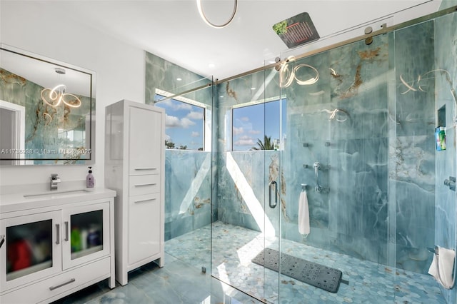 full bath featuring a marble finish shower and vanity