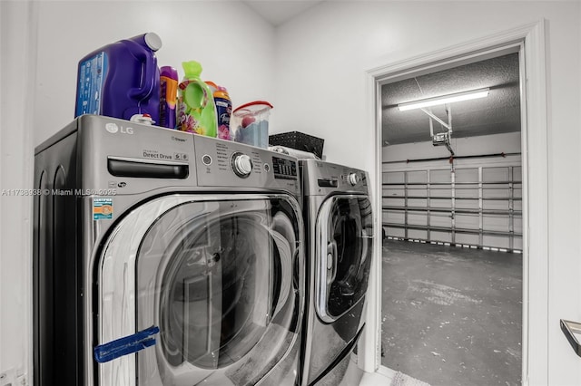 laundry room featuring a garage, laundry area, a textured ceiling, and independent washer and dryer