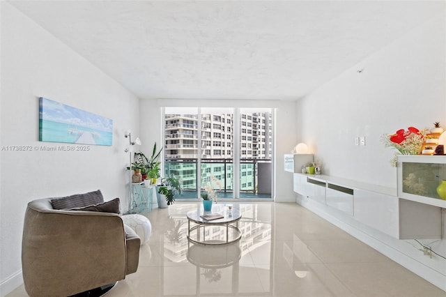 living area featuring floor to ceiling windows, baseboards, and tile patterned floors