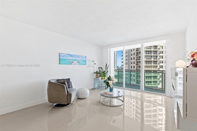 sitting room with floor to ceiling windows and baseboards