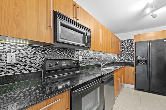 kitchen with dark stone counters, a sink, black appliances, backsplash, and light tile patterned flooring