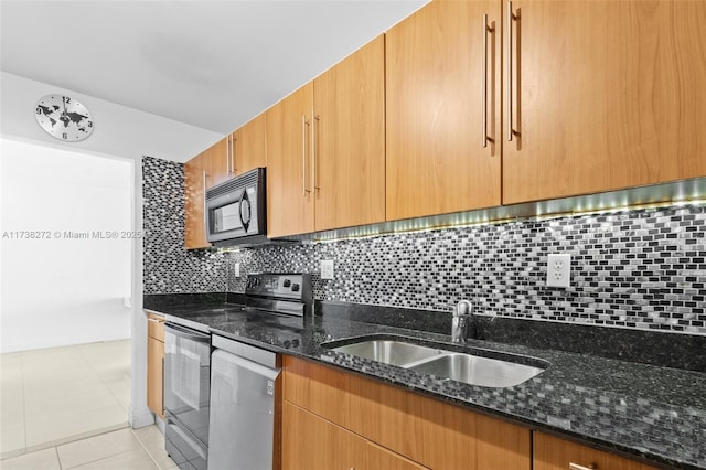 kitchen with black microwave, a sink, stainless steel dishwasher, electric range oven, and dark stone countertops