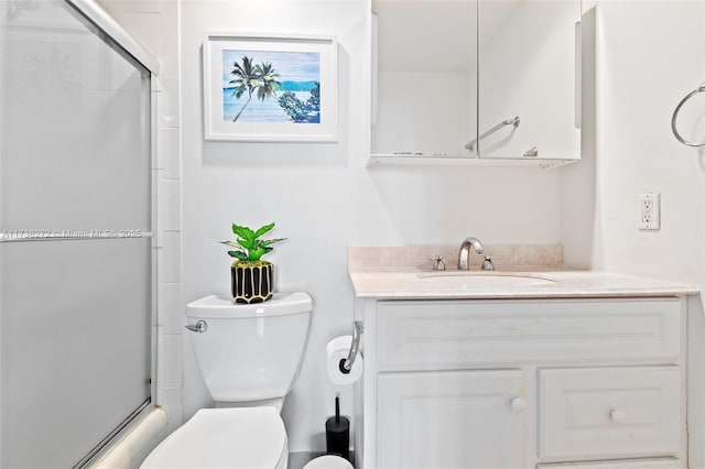 full bathroom featuring toilet, a shower with door, and vanity