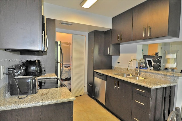 kitchen featuring dark brown cabinetry, dishwasher, sink, and light stone countertops