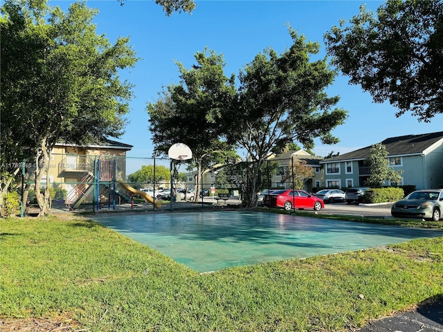 exterior space with a yard, basketball hoop, and a playground