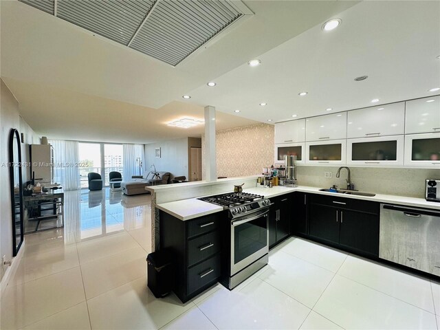 kitchen with sink, light tile patterned floors, white cabinets, and appliances with stainless steel finishes