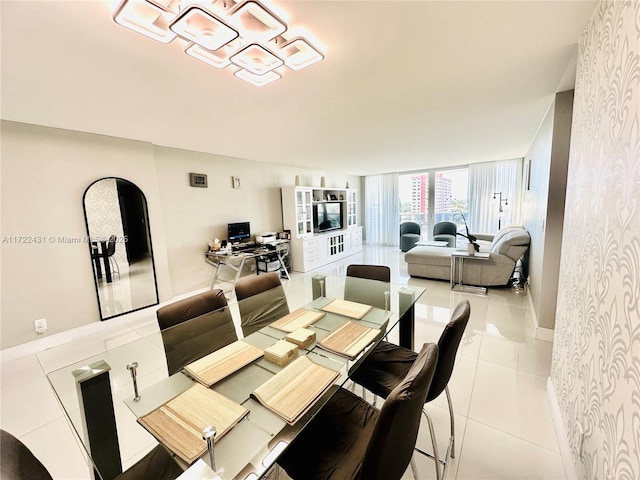 dining room featuring baseboards, floor to ceiling windows, arched walkways, and tile patterned floors