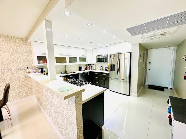 kitchen with light tile patterned floors, visible vents, appliances with stainless steel finishes, and wallpapered walls