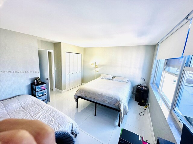 bedroom with light tile patterned flooring and a closet