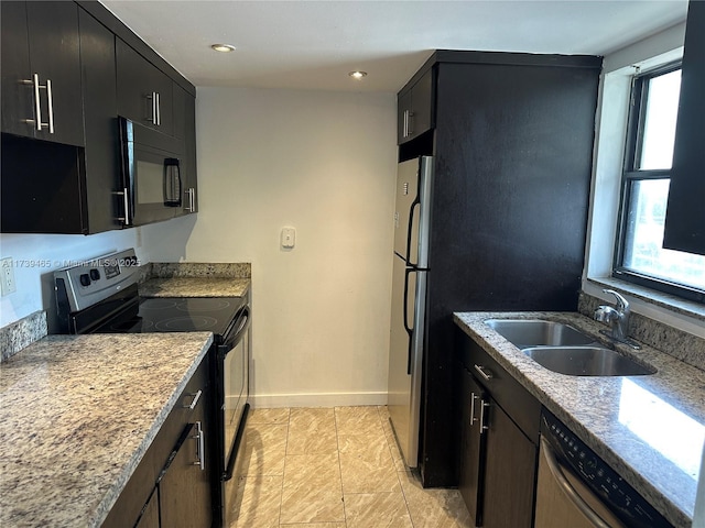 kitchen featuring recessed lighting, a sink, black appliances, dark cabinets, and baseboards