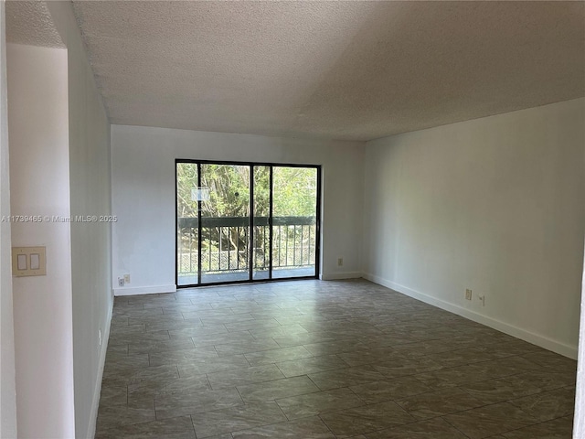 unfurnished room featuring baseboards and a textured ceiling