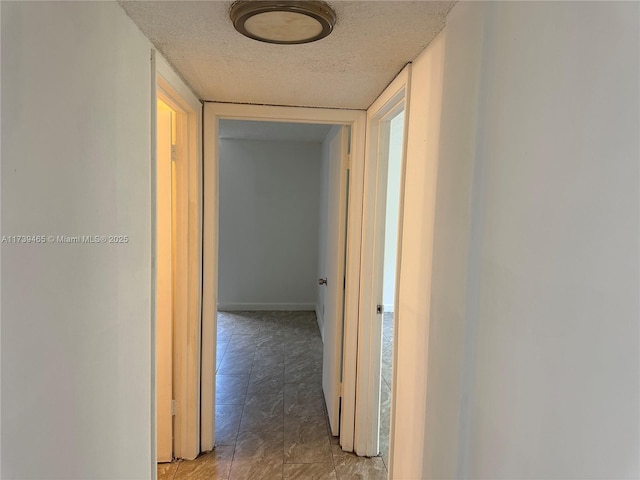 corridor featuring a textured ceiling