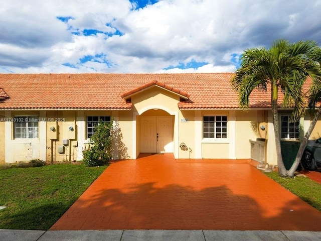 mediterranean / spanish home featuring a front yard