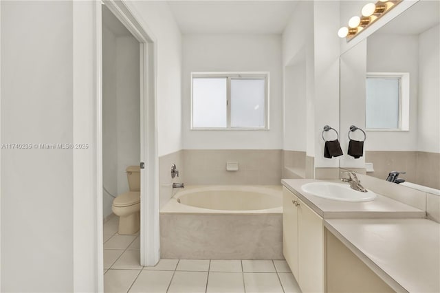 bathroom featuring vanity, a bathtub, tile patterned floors, and toilet