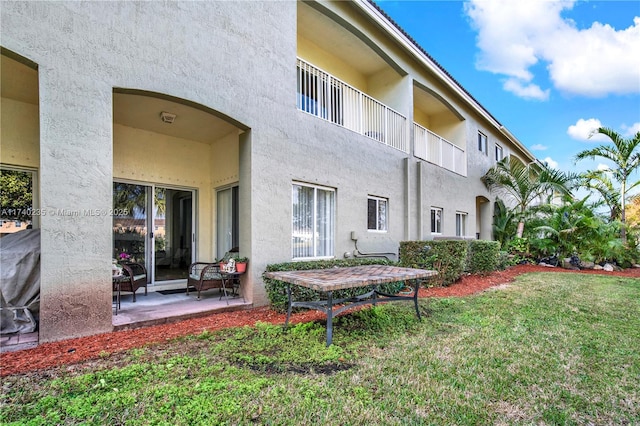 back of property with a patio and a lawn