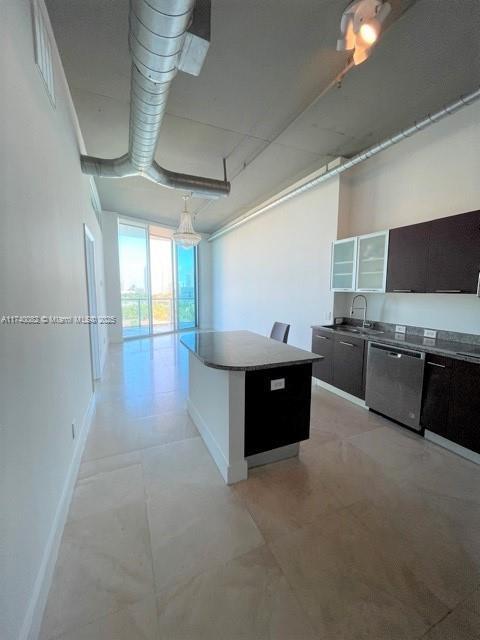 kitchen featuring a kitchen island, sink, and stainless steel dishwasher