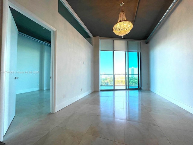 unfurnished room featuring baseboards and a wall of windows