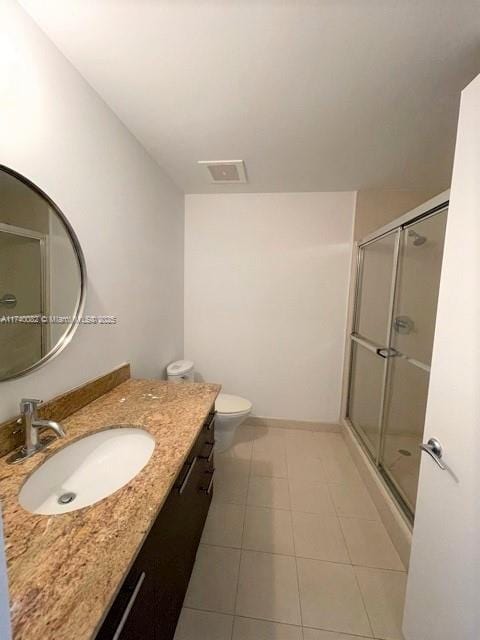 bathroom with vanity, toilet, tile patterned floors, and walk in shower