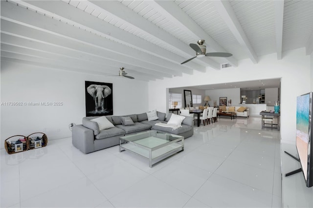 tiled living room with beam ceiling and ceiling fan