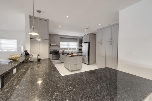 kitchen featuring stainless steel appliances, a kitchen island, hanging light fixtures, and gray cabinetry