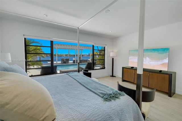 bedroom with a water view and light hardwood / wood-style floors