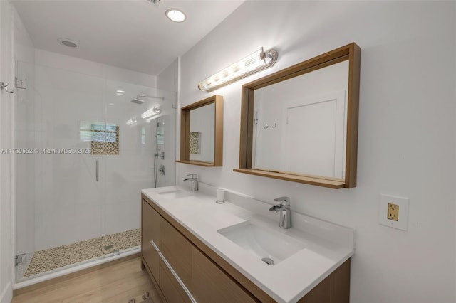 bathroom with an enclosed shower, vanity, and wood-type flooring